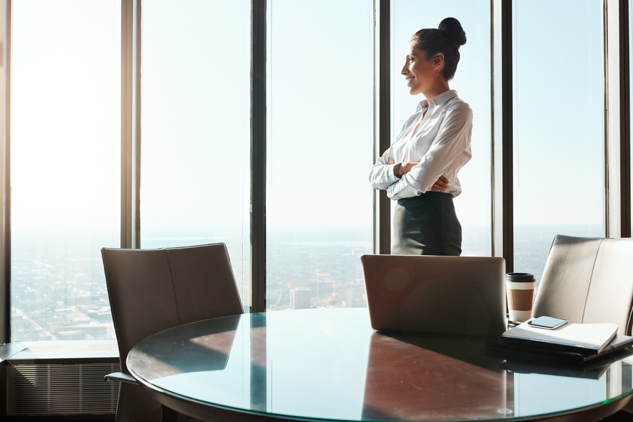 A woman standing looking out a window