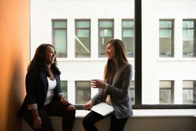 Business women talking by window; HR - human resources - small business meeting
