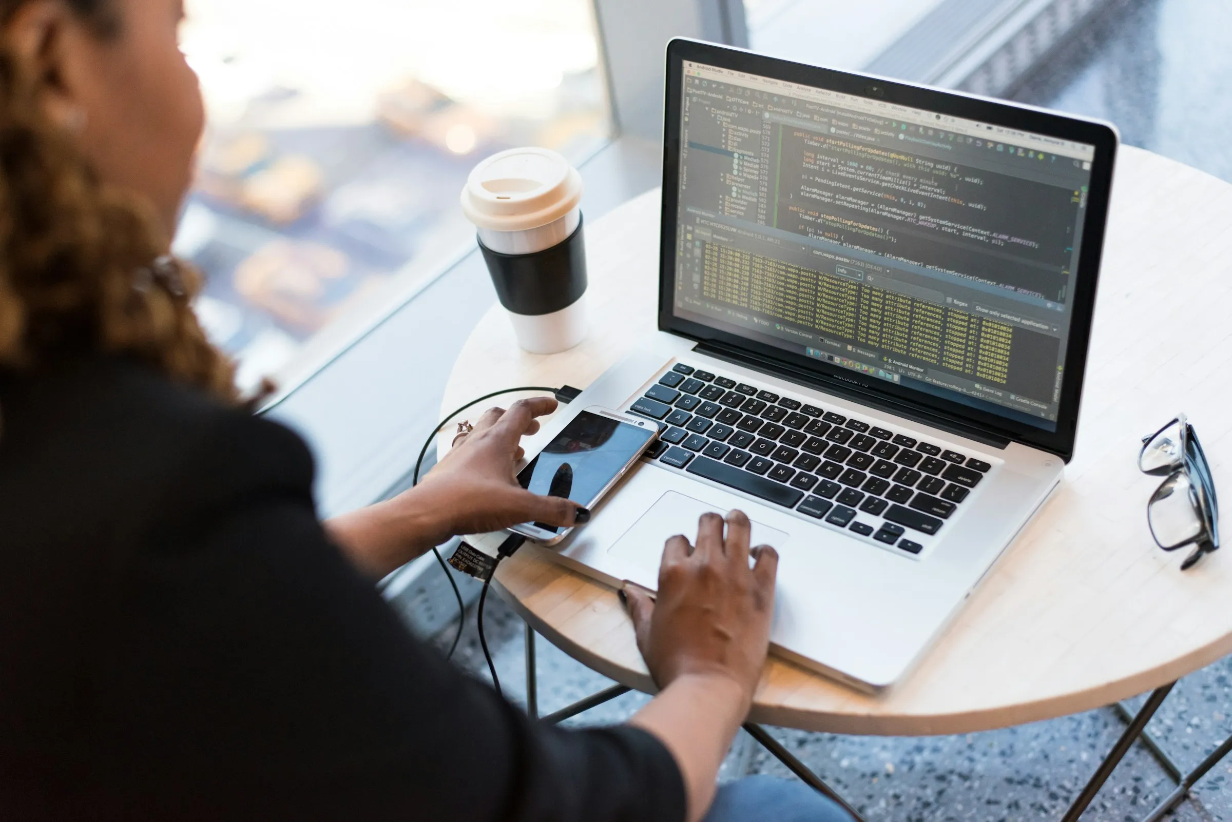 Hispanic woman on laptop by a window