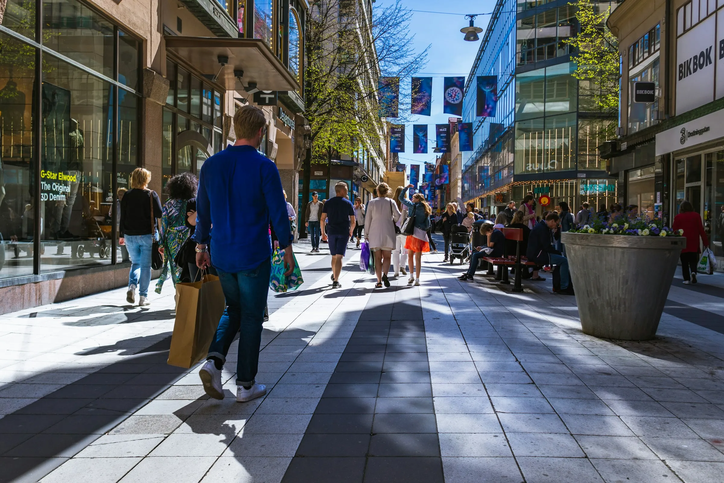a city streetview of people shopping outside.
